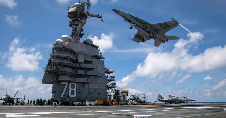 ইউএসএস জেরাল্ড আর. ফোর্ডের ফ্লাইট ডেকের ওপর দিয়ে উড়ে যাচ্ছে একটি এফ/এ-১৮ই সুপার হর্নেট